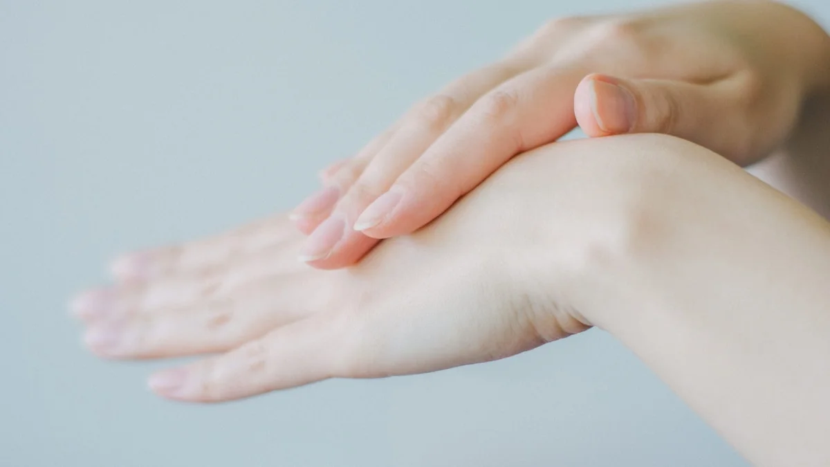 serene close-up of hands gently massaging ears, soft focus, calming background, natural skin tones